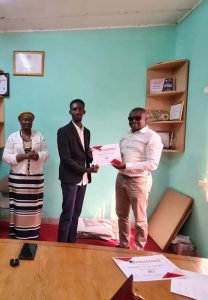 AYV CEO Amb Junior Navo presenting award to one of the students 